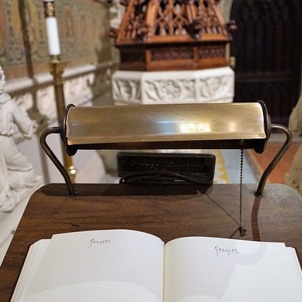 Ein leerer Holztisch mit einem offenen Buch in einer Kirche.