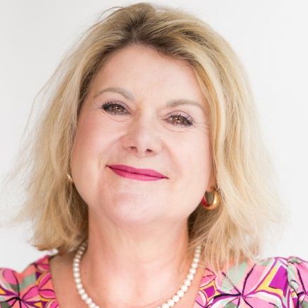 Persönliche, individuelle Trauerreden - jede Rede ein Unikat Lächelnde Frau mit blonden Haaren in buntem, gemustertem Kleid.